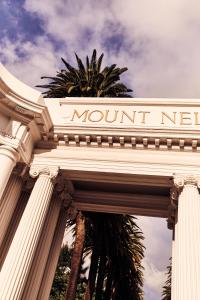 开普敦Mount Nelson, A Belmond Hotel, Cape Town的棕榈树旁纪念碑前的标志