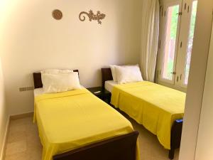 赫尔格达South marina apartment MS10 Wi-Fi available的配有黄色床单的客房内的两张床