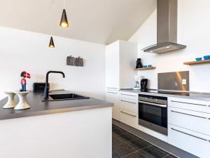 博恩瑟4 person holiday home in Bogense的厨房配有白色橱柜和水槽