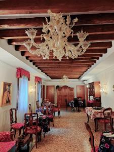 威尼斯洛坎达卡弗摩萨酒店的一间带吊灯和桌椅的用餐室