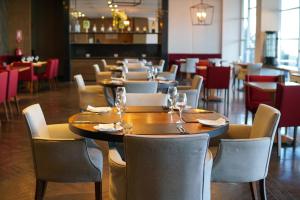 利纳雷斯Hotel Parada Linares的餐厅内带桌椅的用餐室