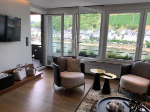 科赫姆摩泽尔公寓的客厅配有椅子、电视和窗户。