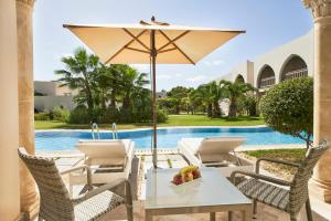 特里法TUI BLUE Palm Beach Palace Djerba - Adult Only的庭院配有桌椅和遮阳伞。