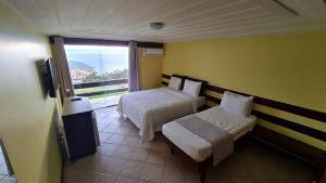 布希奥斯Pousada Mirante dos Papagaios的酒店客房设有两张床和一个阳台。