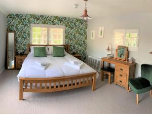 MoulsfordFerryman`s Cottage at The Beetle & Wedge的一间卧室配有一张床、一张桌子和一把椅子