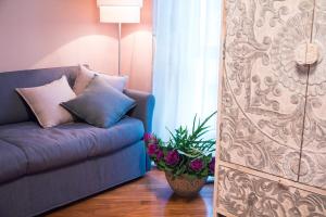 阿尔巴阿格尼斯住宿加早餐旅馆的客厅里摆放着蓝色的沙发,上面有植物