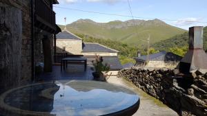 San CipriánCasa Rural Las Nieves的山景庭院设有玻璃桌