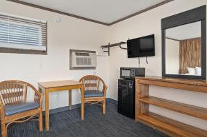 大洋城Beach Bum Inn的配有桌子、电视和桌椅的房间