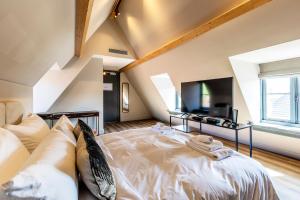 NieuwersluisBistrotel 't Amsterdammertje的卧室配有一张白色大床和电视。