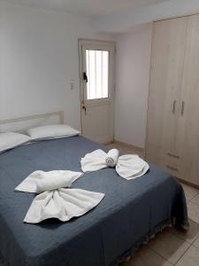 锡蒂亚Sitia Holidays 2的一间卧室,在蓝色的床上配有2条白色毛巾