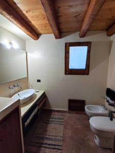 CollesanoVilla Degli Ulivi的一间带两个盥洗盆、卫生间和窗户的浴室