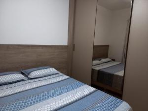 伦索伊斯Lindo Apartamento em Lençóis的一间卧室配有两张床和镜子
