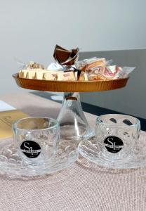 都灵SKY LOFT Nuovissimo vicinanze Metro的一张桌子,上面放着两杯清澈的玻璃杯和一篮子的食物