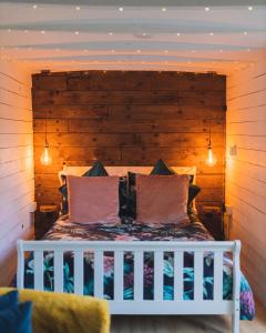 GaradiceThe Horrrsebox Tinyhouse Glamping的卧室配有白色的床和木制床头板