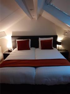 雷嫩Bed & Breakfast Trouwborst的一间卧室配有一张大床和两个红色枕头