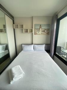 芭堤雅市中心The Base in pattaya的卧室设有一张白色大床和一扇窗户。