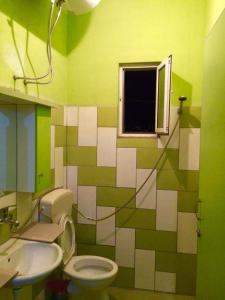 培拉特Guesthouse Aleksander的绿色和白色的浴室设有卫生间和窗户