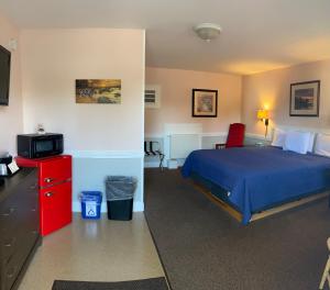 BucksportBucksport Inn的一间卧室配有蓝色的床和红色梳妆台