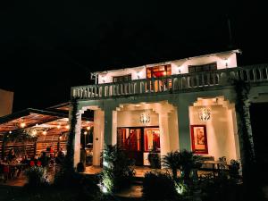 巴尼奥斯593 Hotel Boutique Baños的白色的建筑,晚上有餐厅