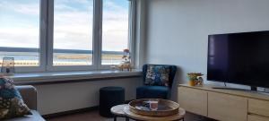 奥斯坦德Vakantie-appartement La Régence @ Oostende的客厅配有平面电视和椅子。