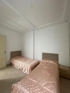 马赫迪耶La maison du Jasmin的白色墙壁客房的两张床