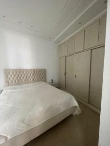 马赫迪耶La maison du Jasmin的白色卧室配有一张大床和橱柜