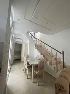 马赫迪耶La maison du Jasmin的一间带桌椅和楼梯的用餐室