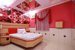 瓜鲁柳斯Motel Vison (Próximo GRU Aeroporto)的一间设有床铺的卧室,位于一个红色墙壁的房间