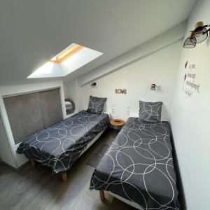 罗什福尔Maison chaleureuse avec terrasse privative proche de la gare的一间卧室设有两张床和天窗