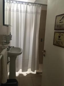 拉里奥哈Departamento PRINGLES - con cochera的浴室设有白色的淋浴帘和水槽