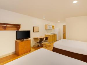 什里夫波特Extended Stay America Select Suites - Shreveport - Airport的酒店客房设有两张床和电视。