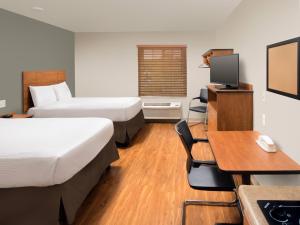 代顿Extended Stay America Select Suites - Dayton - Miamisburg的酒店客房配有两张床和一张书桌