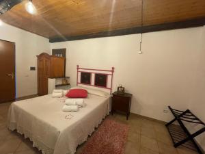 阿尔比尼娅Casa nel verde的一间卧室配有一张带红色枕头的床