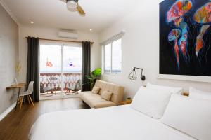 博卡斯德尔托罗Divers Paradise Boutique Hotel的卧室配有白色的床和沙发