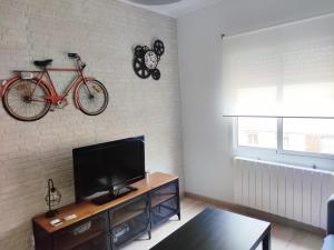 希洪Apartamento Casa Aurelio的客厅配有电视,墙上有自行车