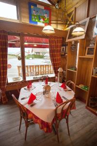 莱鲁斯Logis hôtel Arbez Franco Suisse的一间用餐室,配有一张带红色餐巾的桌子
