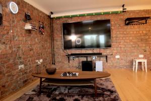 里加Mini cinema & movie studio with PS5的墙上有大屏幕电视的砖墙