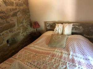 Saint-AppolinaireLE CHALET de la goutte的一间卧室配有一张带枕头的床