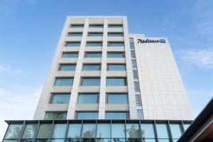 克卢日-纳波卡Radisson Blu Hotel, Cluj的一座高大的白色建筑,上面有标志