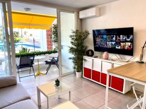 法纳贝海滩Adeje Beach Holiday Home Viña del Mar的客厅配有平面电视和桌子。
