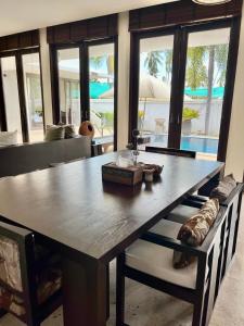 Ban Ang ThongVilla Nirwana - Jasmin 3BR with private pool的一间带桌子和沙发的用餐室