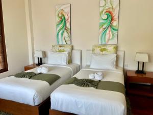 Ban Ang ThongVilla Nirwana - Jasmin 3BR with private pool的两张位于酒店客房的床,上面有鲜花