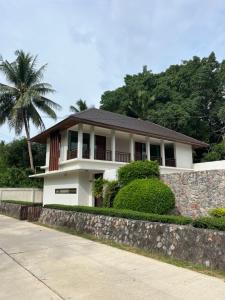 Ban Ang ThongVilla Nirwana - Jasmin 3BR with private pool的墙上有棕榈树的白色房子