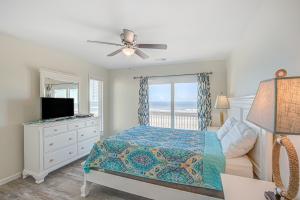 托普赛尔海滩Avalon Topsail Beach的一间卧室配有一张床、一台电视和一个窗口