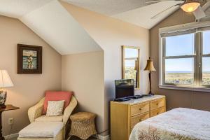 托普赛尔海滩Baylin A的卧室配有床、椅子和窗户。