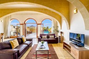 KerċemFour Winds Holiday Home的带沙发和电视的客厅