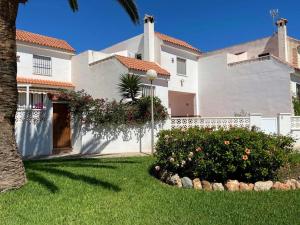 滨海罗克塔斯Modern holiday home in Roquetas de Mar with private terrace的一座白色的大房子,有树的院子