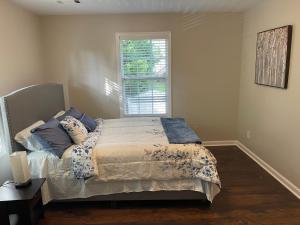 比福德Stylish and Cozy Retreat的一间卧室配有一张带蓝色枕头的床和一扇窗户。