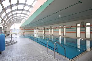 大分伦勃朗奥塔酒店的一座带玻璃天花板的建筑中的游泳池
