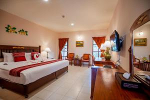 芭东海滩Phuket Leelavadee Hua Ting Resort的一间带大床的卧室和一间客厅